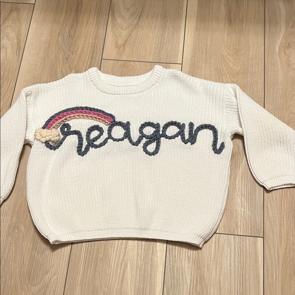 CUSTOM Girl’s Cream Sweater with Rainbow Detail with the name Reagan